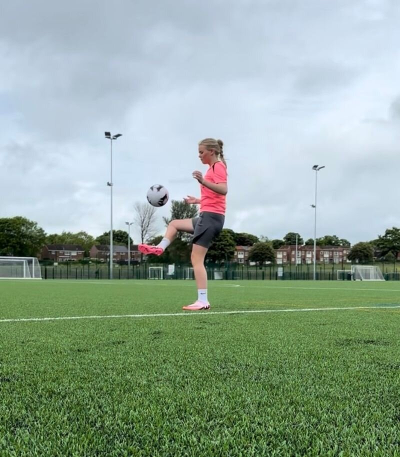 Emily playing football in nike football boots